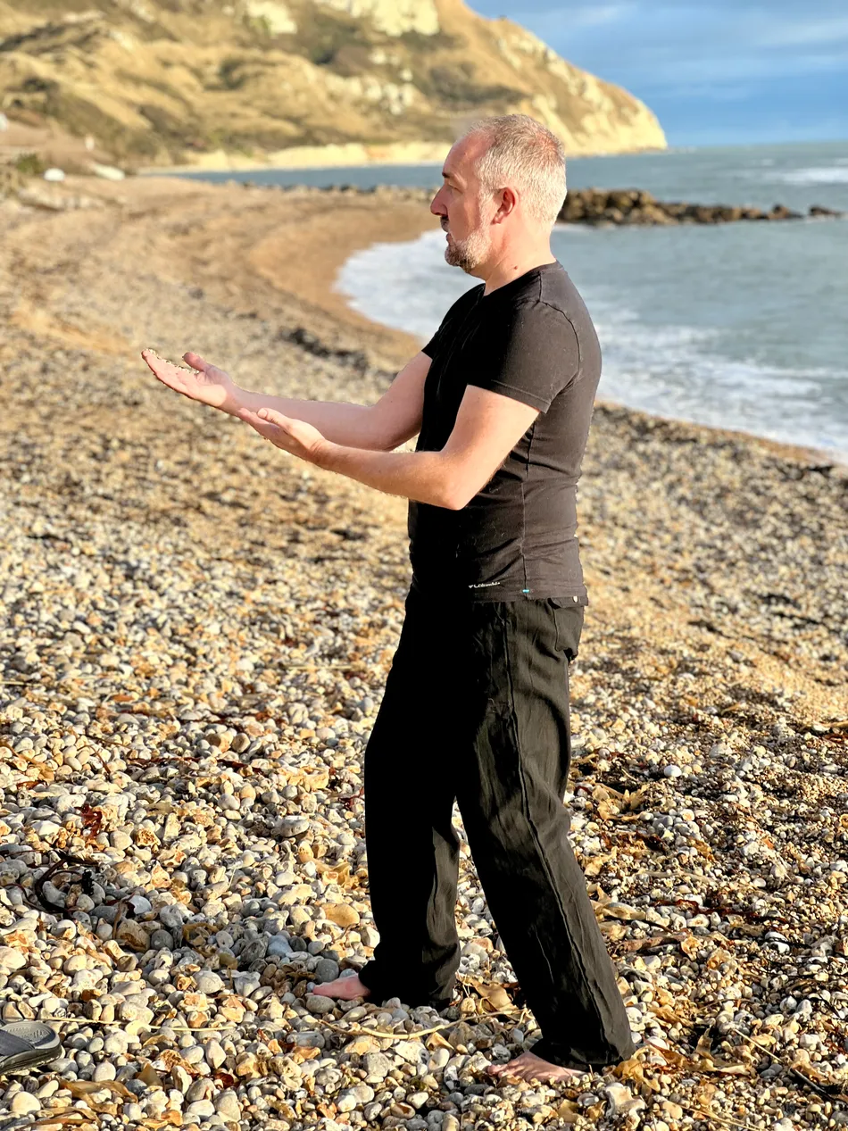 Andrew Lowe performing tai chi on a beach1